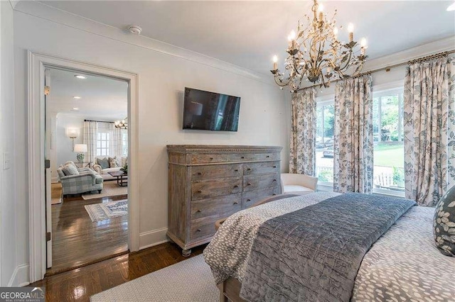 bedroom featuring an inviting chandelier, baseboards, ornamental molding, and wood finished floors