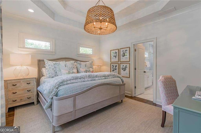 bedroom featuring baseboards, a chandelier, multiple windows, and ensuite bathroom