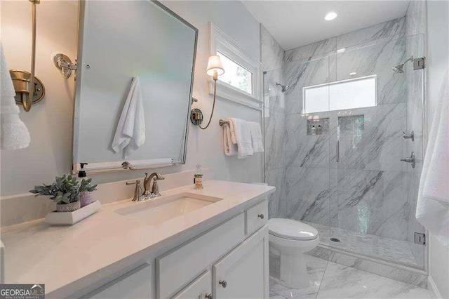 full bath with toilet, a marble finish shower, marble finish floor, and vanity