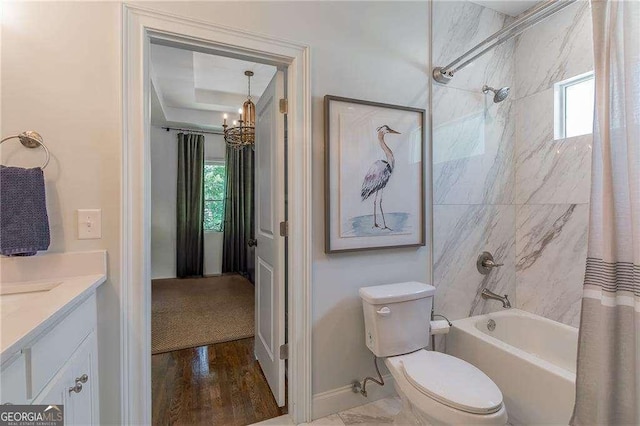 bathroom with plenty of natural light, vanity, shower / bath combo, and an inviting chandelier