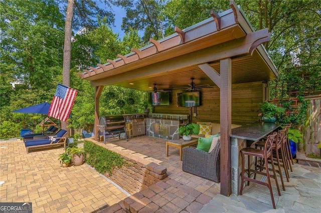 view of patio with ceiling fan, outdoor dry bar, and a grill
