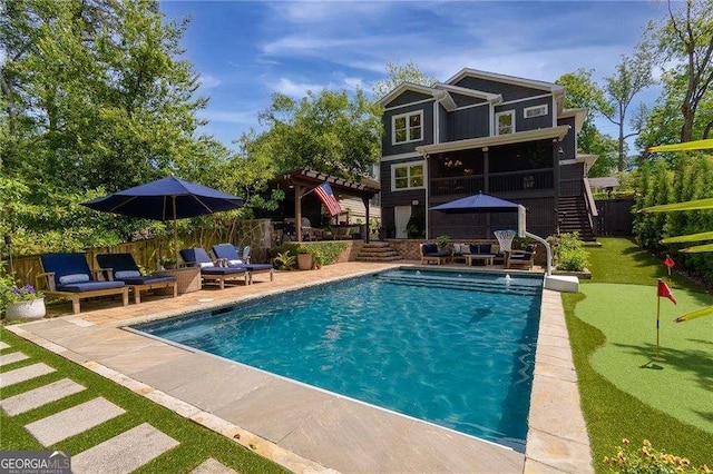 view of swimming pool with a patio, an outdoor living space, and stairway