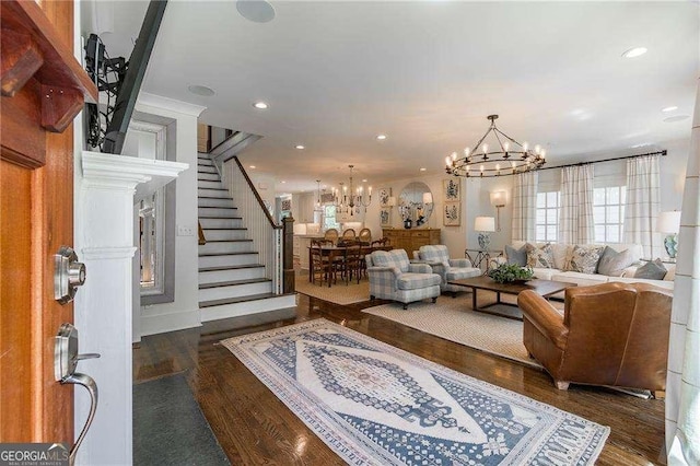 living area with stairway, recessed lighting, wood finished floors, and a chandelier