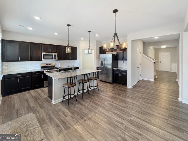 376 Layfield Dr, Jonesboro, GA 30238 - kitchen with a sink, light wood finished floors, stainless steel appliances, decorative backsplash, and a kitchen bar