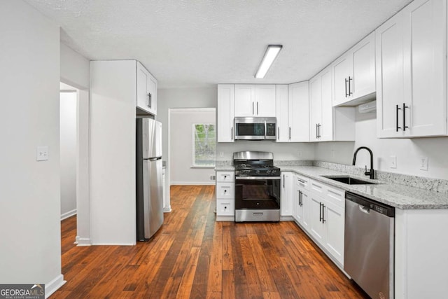 3688 Burnley Ct, Lithonia, GA 30038 - kitchen with a sink, stainless steel appliances, white cabinetry, and dark wood-type flooring