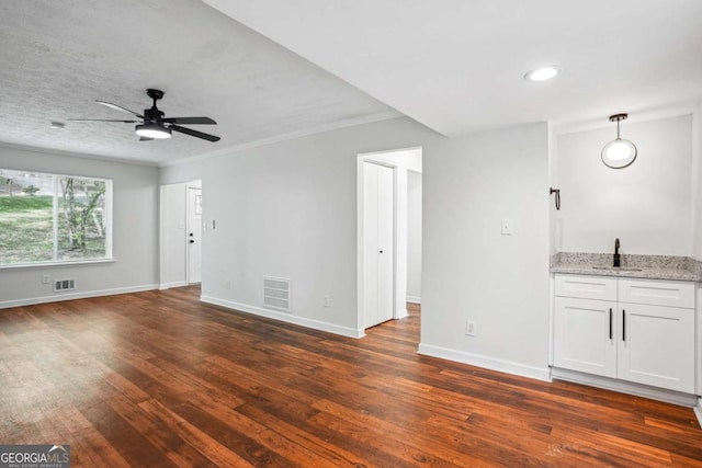 3688 Burnley Ct, Lithonia, GA 30038 - unfurnished living room featuring a ceiling fan, dark wood-style flooring, visible vents, a sink, and baseboards