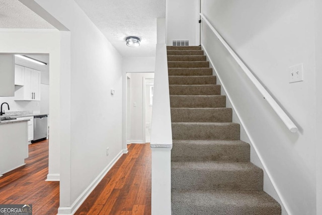 3688 Burnley Ct, Lithonia, GA 30038 - staircase with wood finished floors and a textured ceiling