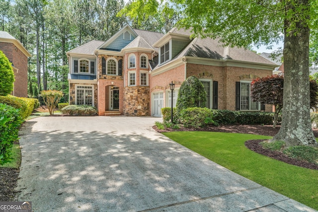 5303 Davenport Mnr, Cumming, GA 30041 - view of front of house with a shingled roof, a front lawn, brick siding, stone siding, and concrete driveway