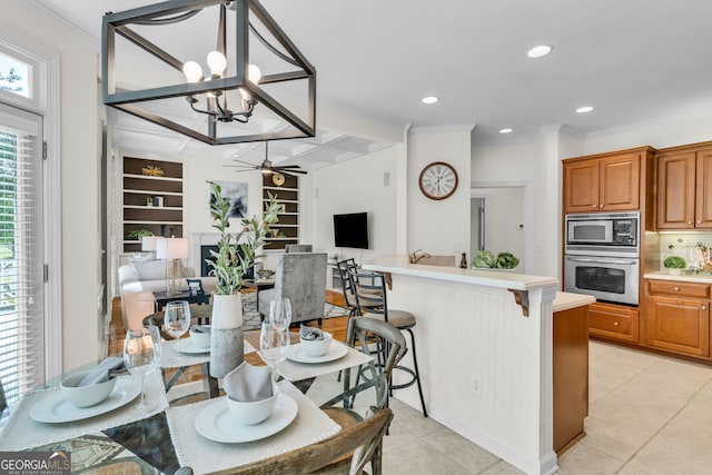 5303 Davenport Mnr, Cumming, GA 30041 - kitchen featuring ceiling fan with notable chandelier, open floor plan, a kitchen breakfast bar, light countertops, and appliances with stainless steel finishes