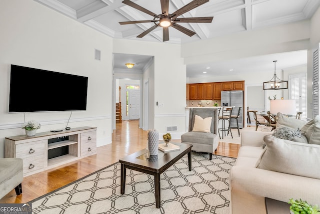 5303 Davenport Mnr, Cumming, GA 30041 - living room with ceiling fan with notable chandelier, light wood-style floors, coffered ceiling, and visible vents