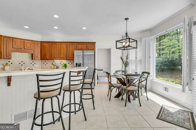 5303 Davenport Mnr, Cumming, GA 30041 - kitchen with stainless steel fridge, ornamental molding, a chandelier, and visible vents