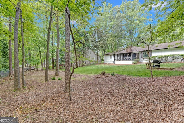 view of grassy yard with a sunroom