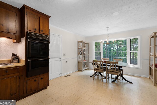 dining area with a textured ceiling, a chandelier, baseboards, and crown molding