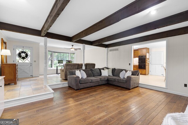 living area with hardwood / wood-style floors, decorative columns, beam ceiling, a ceiling fan, and baseboards