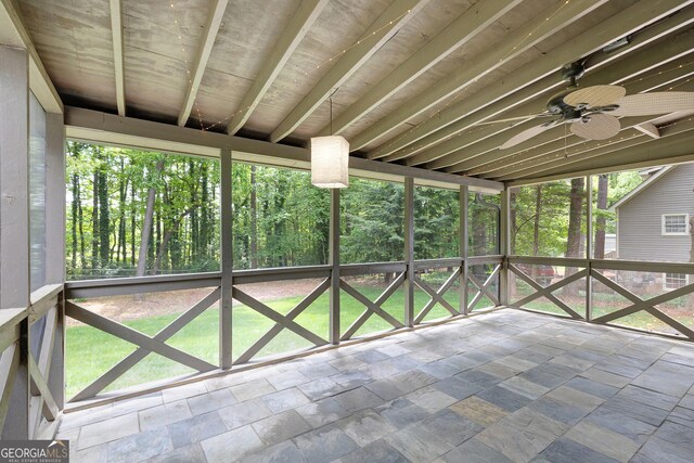 unfurnished sunroom featuring a ceiling fan