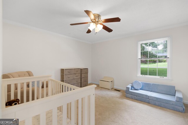 carpeted bedroom with ornamental molding, baseboards, and ceiling fan