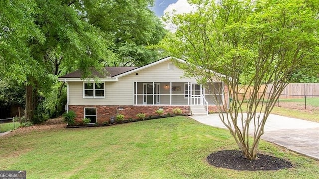 848 E Ave, Scottdale, GA 30079 - ranch-style home with driveway, a sunroom, brick siding, fence, and a front lawn