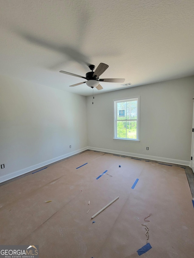 spare room featuring baseboards, ceiling fan, a textured ceiling, and visible vents