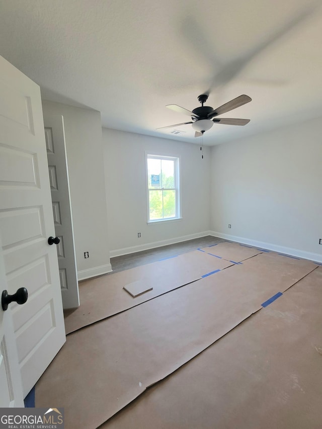 empty room featuring baseboards, ceiling fan, and concrete floors