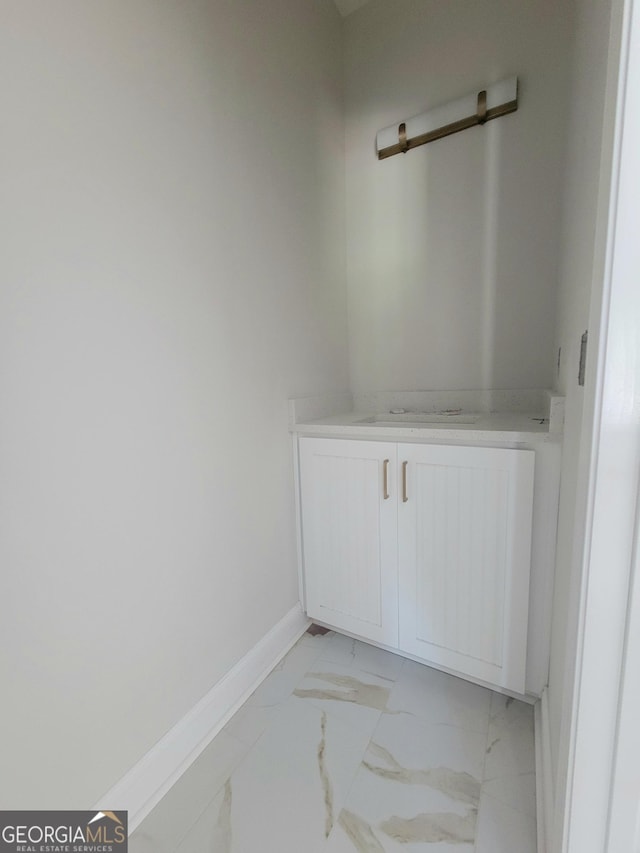 interior space with baseboards and marble finish floor