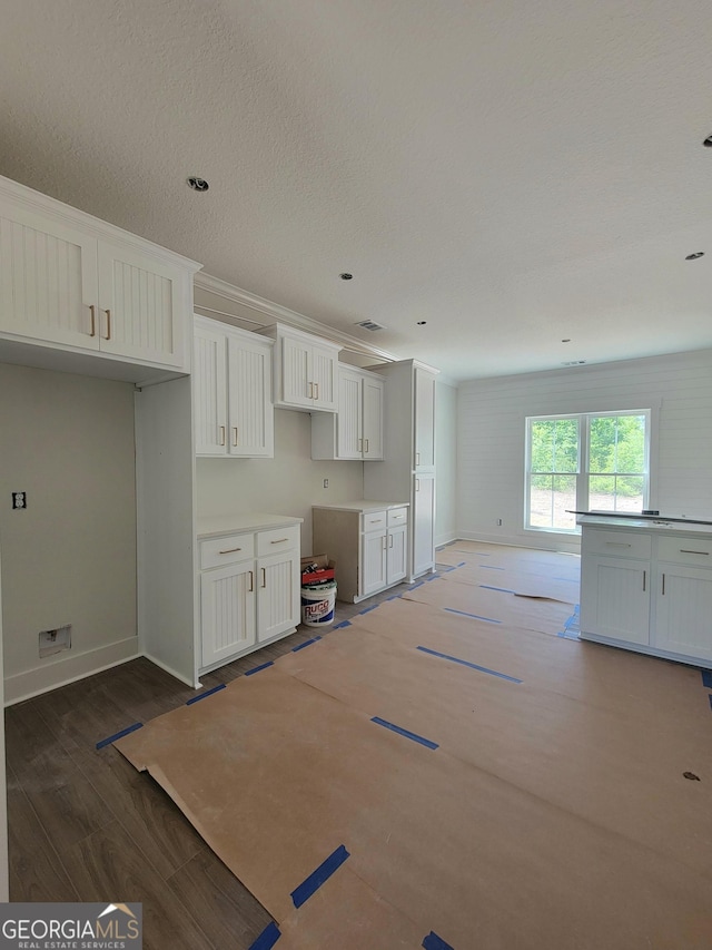 kitchen with baseboards, white cabinetry, and wood finished floors