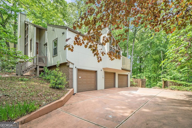 1213 Laurel Cliff Dr SE, Smyrna, GA 30082 - view of side of property with fence, an attached garage, driveway, and a balcony