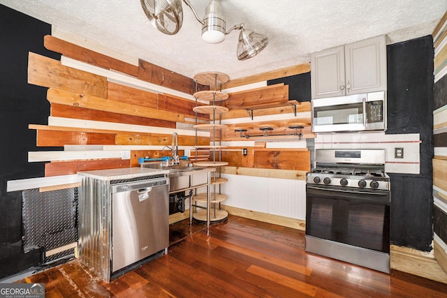 1213 Laurel Cliff Dr SE, Smyrna, GA 30082 - kitchen with stainless steel appliances, a textured ceiling, a sink, and wood finished floors