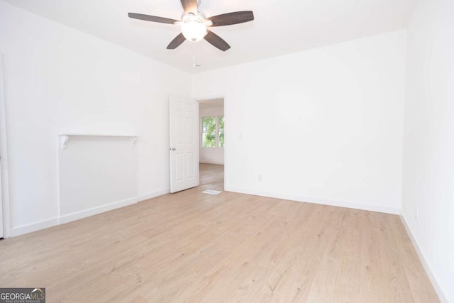 empty room with baseboards, a ceiling fan, and wood finished floors