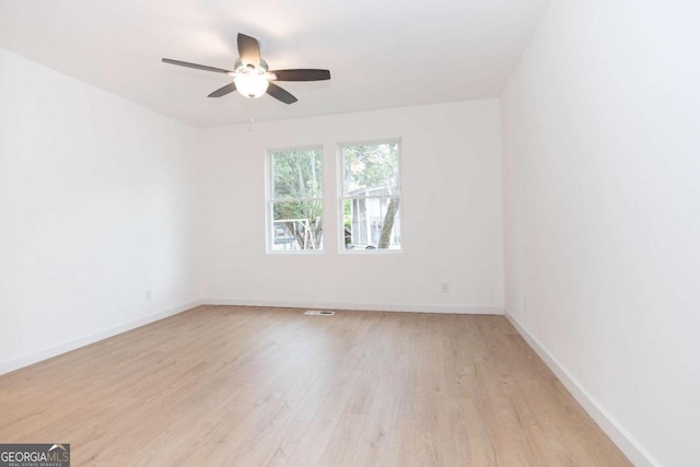 unfurnished room featuring a ceiling fan, baseboards, and light wood-style floors