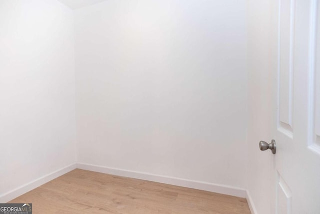 unfurnished room featuring baseboards and light wood-style floors
