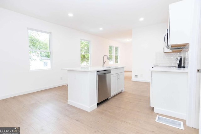 kitchen featuring visible vents, stove, dishwasher, a sink, and light countertops