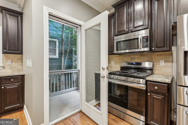 737 St Charles Ave NE, Atlanta, GA 30306 - kitchen featuring stainless steel appliances, light wood-style floors, tasteful backsplash, dark brown cabinetry, and crown molding