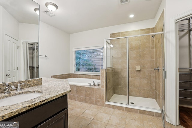 737 St Charles Ave NE, Atlanta, GA 30306 - bathroom with a shower stall, a bath, tile patterned flooring, vanity, and a closet