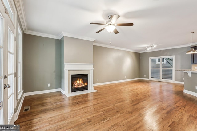 737 St Charles Ave NE, Atlanta, GA 30306 - unfurnished living room featuring wood finished floors, a glass covered fireplace, ceiling fan, ornamental molding, and baseboards