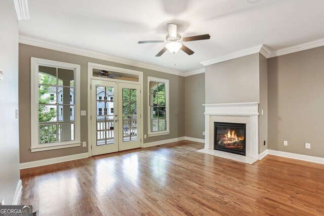 737 St Charles Ave NE, Atlanta, GA 30306 - unfurnished living room featuring ceiling fan, wood finished floors, a fireplace with flush hearth, crown molding, and baseboards