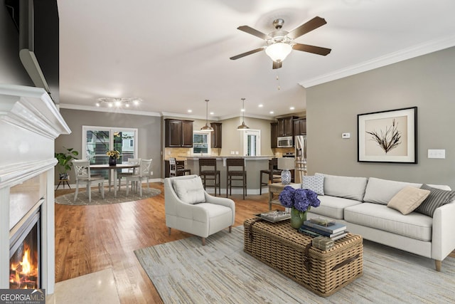 737 St Charles Ave NE, Atlanta, GA 30306 - living area with a warm lit fireplace, ornamental molding, a ceiling fan, light wood-type flooring, and recessed lighting