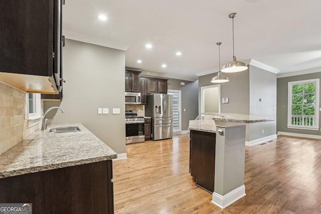 737 St Charles Ave NE, Atlanta, GA 30306 - kitchen with stainless steel appliances, a sink, crown molding, dark brown cabinets, and tasteful backsplash