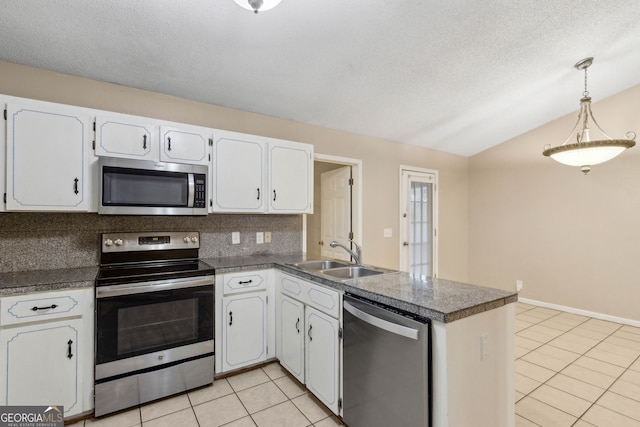 kitchen with a sink, appliances with stainless steel finishes, lofted ceiling, and light tile patterned floors