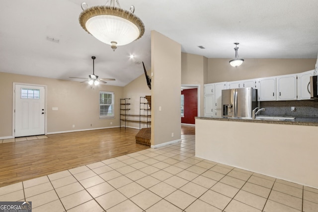 kitchen with white cabinets, ceiling fan, appliances with stainless steel finishes, light wood finished floors, and lofted ceiling