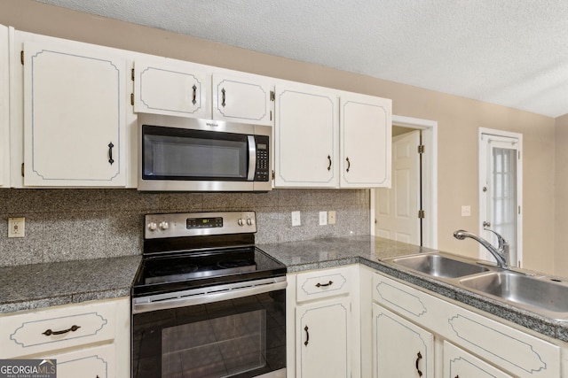 kitchen featuring a sink, appliances with stainless steel finishes, tasteful backsplash, and white cabinets