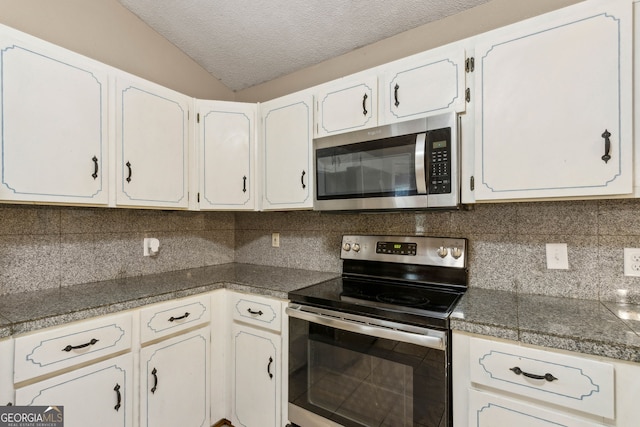 kitchen featuring appliances with stainless steel finishes, a textured ceiling, tile countertops, backsplash, and vaulted ceiling