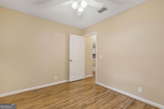 unfurnished room featuring visible vents, light wood-style flooring, and baseboards