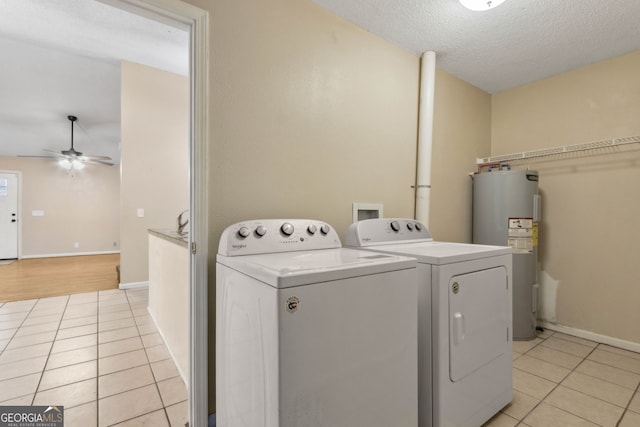 clothes washing area with water heater, light tile patterned floors, laundry area, and washer and dryer