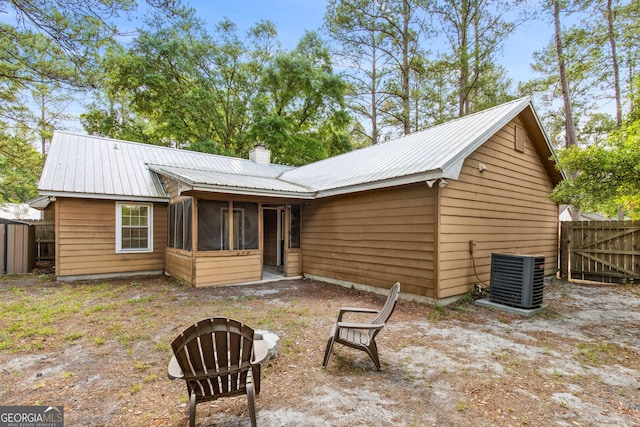 back of house featuring fence, a sunroom, cooling unit, and metal roof