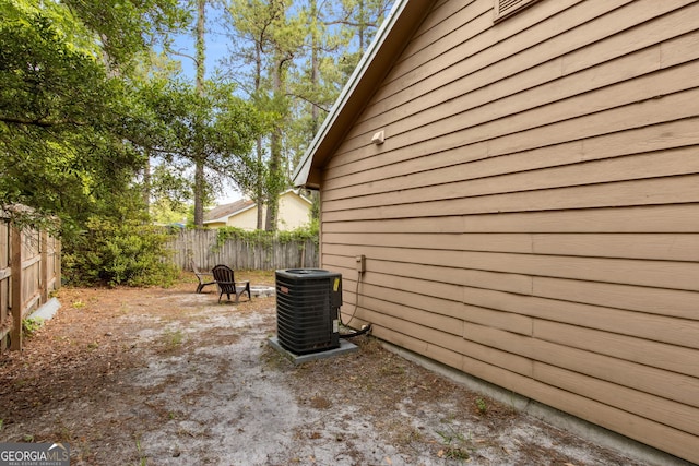 view of property exterior featuring fence and central AC unit