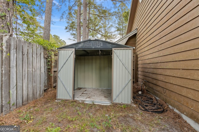 view of shed featuring fence