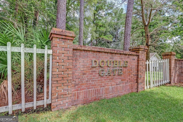 community / neighborhood sign featuring fence
