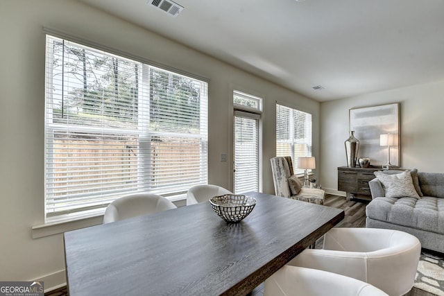dining area featuring baseboards, visible vents, and wood finished floors