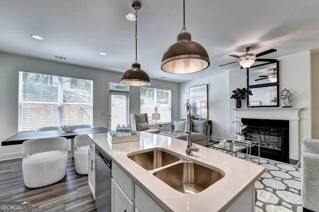 kitchen featuring a sink, light countertops, dishwasher, and open floor plan