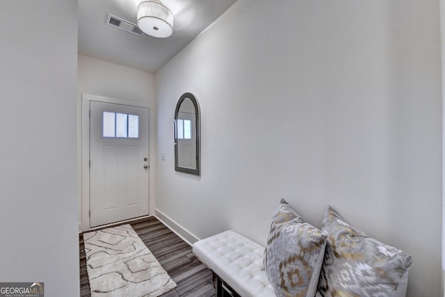 foyer with baseboards, visible vents, and wood finished floors